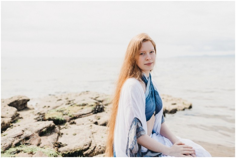 girl sitting on rocks on a beach