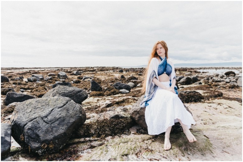 girl sitting on rocks on a beach