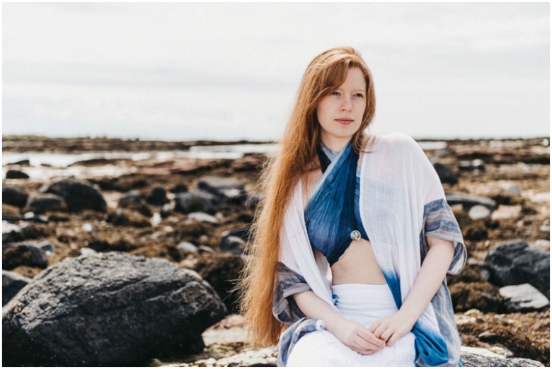 girl sitting on rocks on a beach