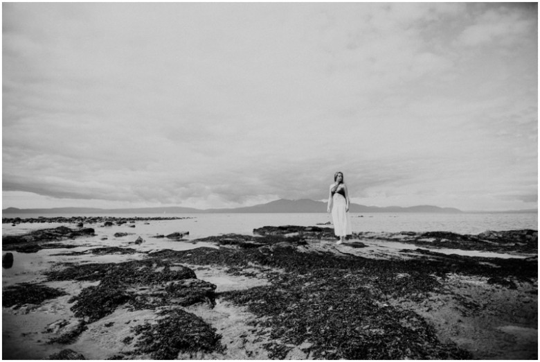 girl standing on rocks on a beach